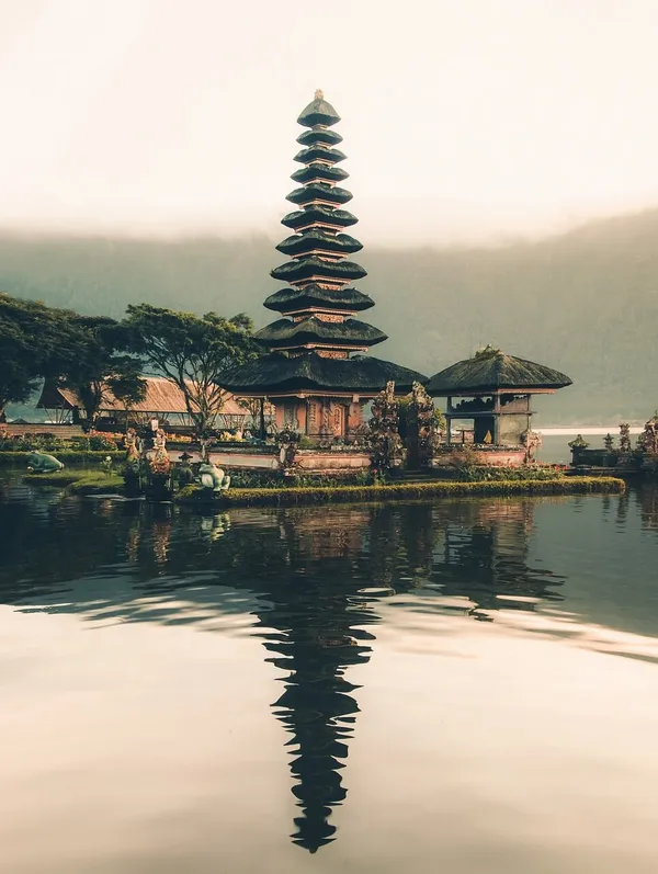 Temple Ulun Danu Beratan et son meru reflétés dans le lac face à la montagne