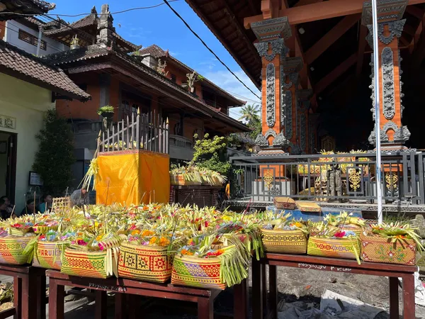 Paniers d’offrandes colorés alignés dans la cour d’un temple balinais